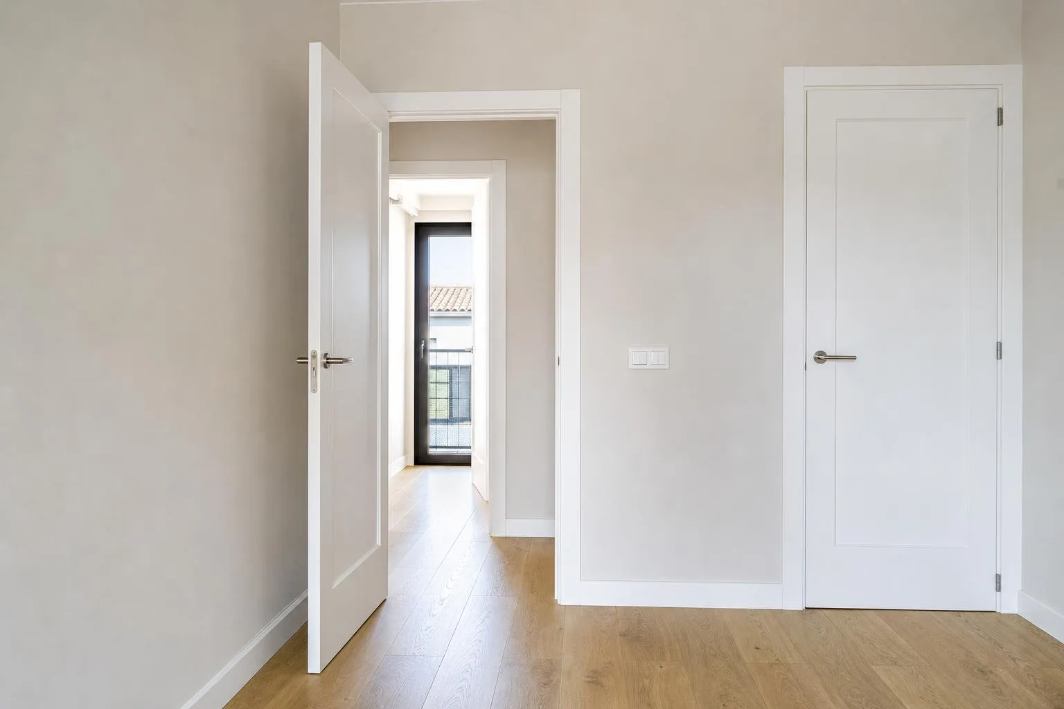Detalle de pared pintada, rodapié y puertas nuevas en un piso reformado